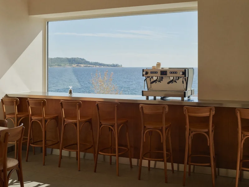 Sonniges Café an der Ostsee mit Holztresen, Espressomaschine und Blick aufs Meer